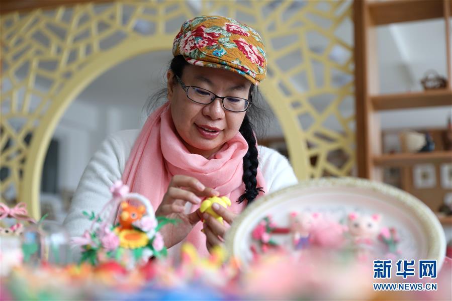 The artist, Jiang Xuejie, is an inheritor of the local clay sculpting technique in east China\'s Rongcheng city, Shandong Province. (Photo/Xinhua)