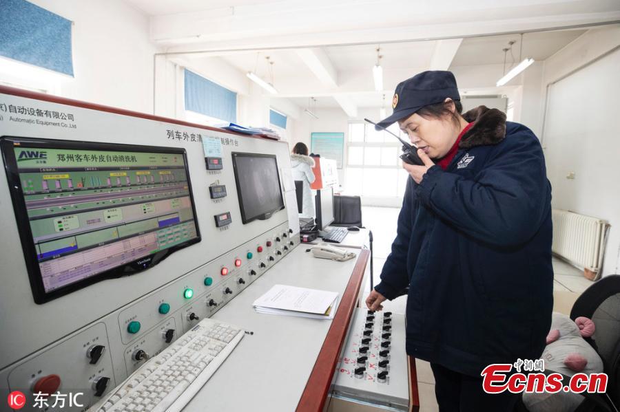 Female workers clean a train at a railway service station in Zhengzhou City, Central China\'s Henan Province. With an average age of 38 years, the workers in the cleaning unit are all female, with the exception of their male head. They are facing an increasing workload due to the Spring Festival travel rush, despite sub-zero temperatures. (Photo/IC)