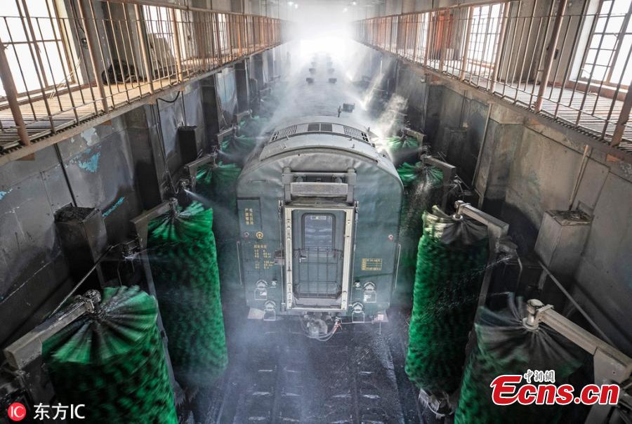 Female workers clean a train at a railway service station in Zhengzhou City, Central China\'s Henan Province. With an average age of 38 years, the workers in the cleaning unit are all female, with the exception of their male head. They are facing an increasing workload due to the Spring Festival travel rush, despite sub-zero temperatures. (Photo/IC)
