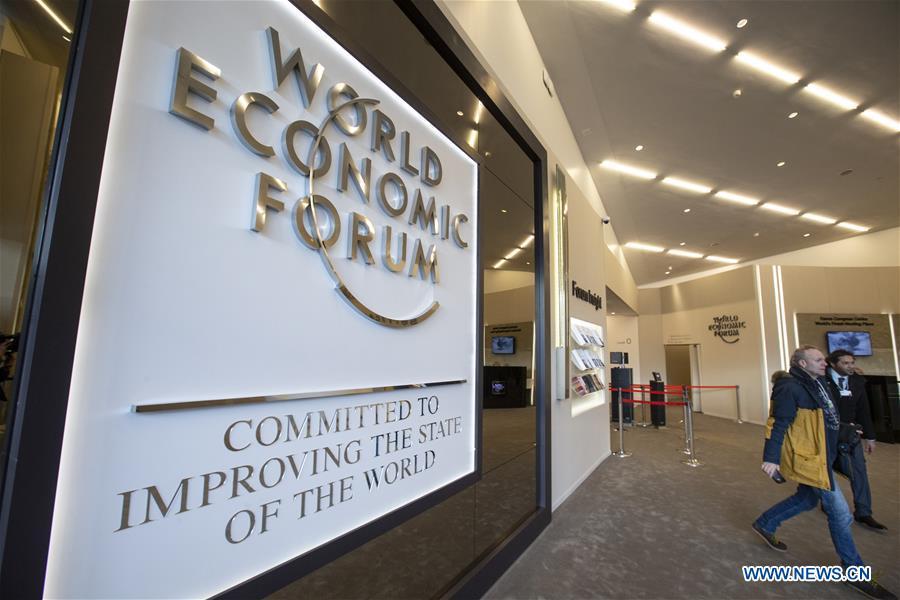 People walk by the logo of the World Economic Forum (WEF) in Davos, Switzerland, Jan. 21, 2019. The WEF Annual Meeting will kick off in Davos on Tuesday. (Xinhua/Xu Jinquan)