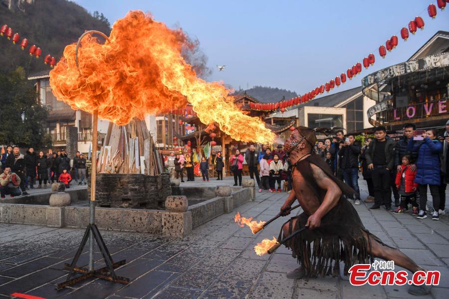 Performers present a fire stunt show at the Wulingyuan scenic area in Zhangjiajie City, Central China\'s Hunan Province, Jan. 21, 2019. Zhangjiajie, a UNESCO World Heritage Site, is known for its forest parks and Wulingyuan is famous for its more than 3,000 sandstone pillars. (Photo: China News Service/Yang Huafeng)