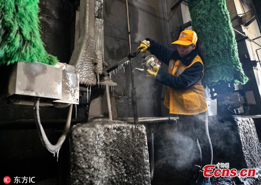 Female workers clean a train at a railway service station in Zhengzhou City, Central China\'s Henan Province. With an average age of 38 years, the workers in the cleaning unit are all female, with the exception of their male head. They are facing an increasing workload due to the Spring Festival travel rush, despite sub-zero temperatures. (Photo/IC)