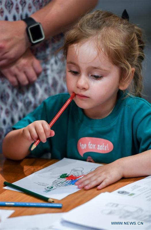 A girl contemplates while coloring a Chinese dragon in Te Papa, the national museum of New Zealand in Wellington, New Zealand, Jan. 23, 2019. A family event, with a theme on \