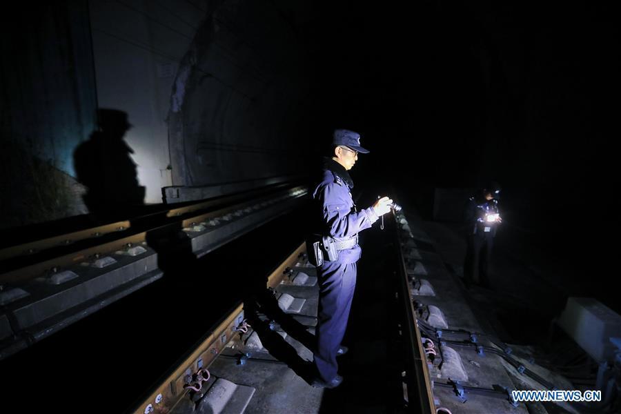 A policeman checks the operation of the facilities along the high-speed railway in Rongjiang County, southwest China\'s Guizhou Province, Jan. 22, 2019. Rongjiang Railway Police Station conducts two or three safety inspections at night every week during the Spring Festival travel rush. (Xinhua/Ou Dongqu)
