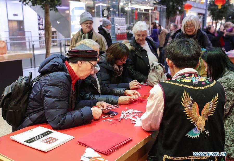 Visitors learn traditional Chinese paper cutting in a shopping mall at Potsdamer Platz in Berlin, capital of Germany, on Jan. 24, 2019. \