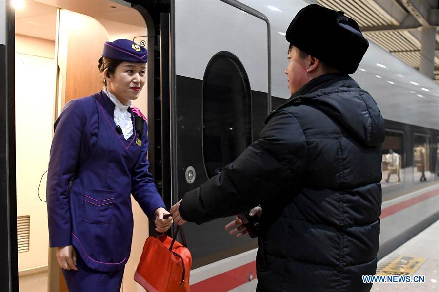 After finishing his work, Li Xiang (R) gives a lunch bag to his wife, Zou Xiaojuan during a temporary stop of the train No. G402 at Xinxiangdong Railway Station in Xinxiang City, central China\'s Henan Province, Jan. 22, 2019. Li Xiang is a staff worker of Xinxiangdong Railway Station and his wife Zou Xiaojuan is a train conductor on the train No. G402. The two-minute stop of the train No. G402 at Xinxiangdong Railway Station is their precious quality time in the bustle during the Spring Festival travel rush. (Xinhua/Li An)