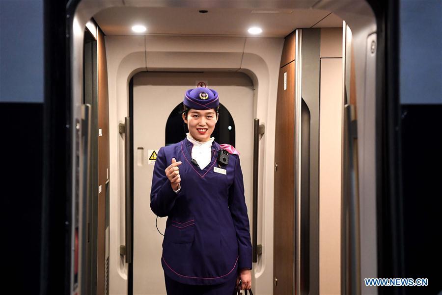 Li Xiang\'s wife, Zou Xiaojuan, poses a gesture symbolizing \'love\' to Li before the departure of the train No. G402 at Xinxiangdong Railway Station in Xinxiang City, central China\'s Henan Province, Jan. 22, 2019. Li Xiang is a staff worker of Xinxiangdong Railway Station and his wife Zou Xiaojuan is a train conductor on the train No. G402. The two-minute stop of the train No. G402 at Xinxiangdong Railway Station is their precious quality time in the bustle during the Spring Festival travel rush. (Xinhua/Li An)
