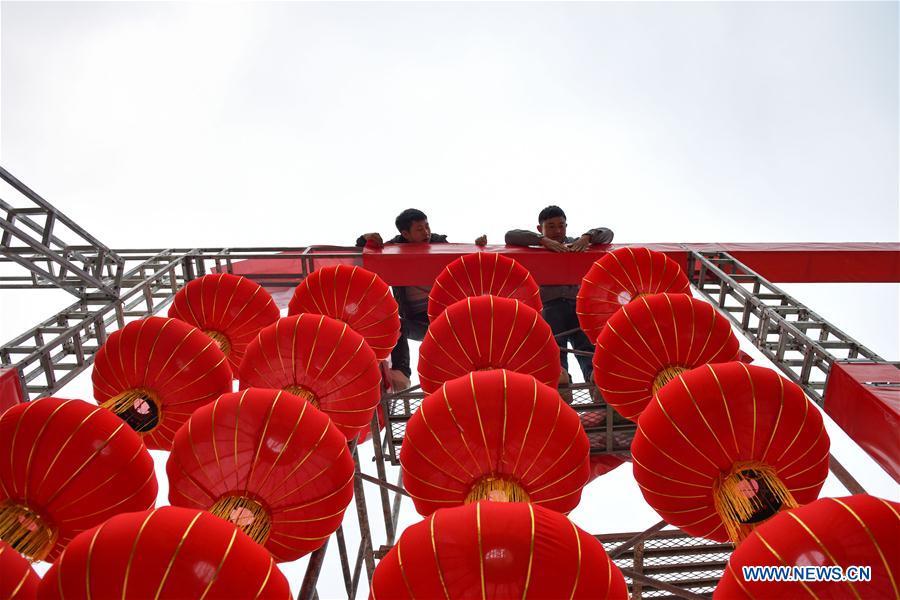 Workers erect red lanterns on the Xinglong Square of Longli County in Bouyei-Miao Autonomous Prefecture of Qiannan, southwest China\'s Guizhou Province, Jan. 24, 2019. Festive decorations are set up across China to greet the lunar New Year, or Spring Festival, which starts from Feb. 5 this year. (Xinhua/Long Yi)