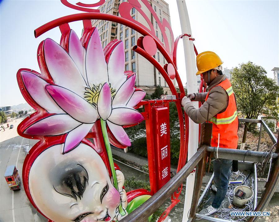 A worker sets up a festive lantern on a street in Guangchang County of Fuzhou City, east China\'s Jiangxi Province, Jan. 24, 2019. Festive decorations are set up across China to greet the lunar New Year, or Spring Festival, which starts from Feb. 5 this year. (Xinhua/Zeng Henggui)
