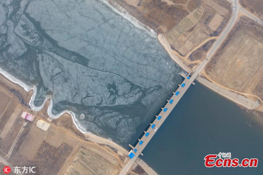 A view of a dam on the Majia River in Wudi County, East China\'s Shandong Province, Jan. 24, 2019. The horse cheek-shaped river dates back to the legendary Yu the Great some 4,000 years ago. Because of a water conservation project, the water is frozen on just one side. (Photo/IC)