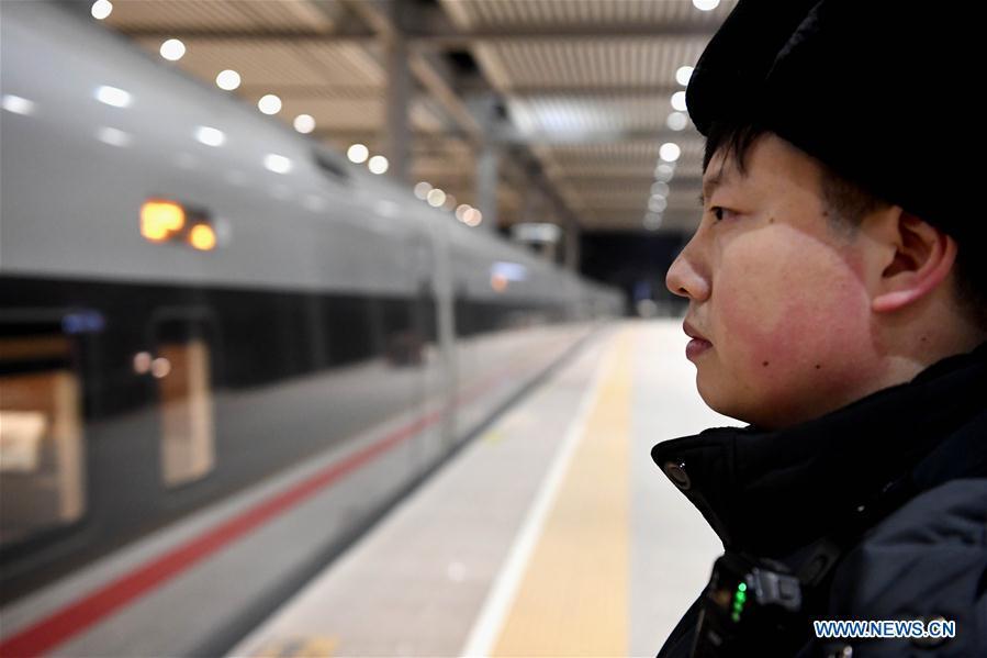 Li Xiang watches the departure of the train No. G402 after its temporary stop at Xinxiangdong Railway Station in Xinxiang City, central China\'s Henan Province, Jan. 22, 2019. Li Xiang is a staff worker of Xinxiangdong Railway Station and his wife Zou Xiaojuan is a train conductor on the train No. G402. The two-minute stop of the train No. G402 at Xinxiangdong Railway Station is their precious quality time in the bustle during the Spring Festival travel rush. (Xinhua/Li An)