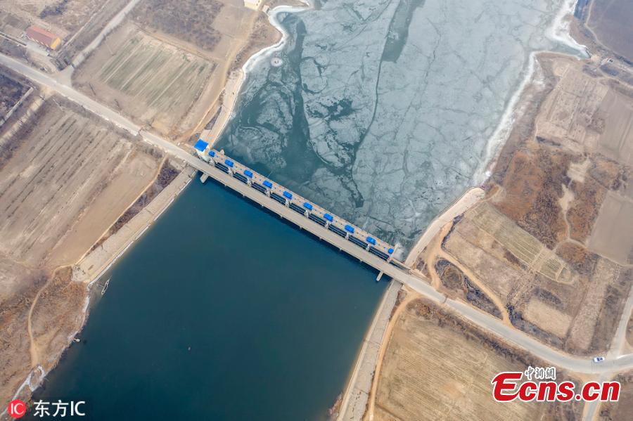 A view of a dam on the Majia River in Wudi County, East China\'s Shandong Province, Jan. 24, 2019. The horse cheek-shaped river dates back to the legendary Yu the Great some 4,000 years ago. Because of a water conservation project, the water is frozen on just one side. (Photo/IC)