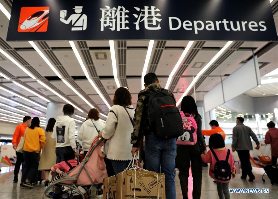 Passengers wait at the departure area in the West Kowloon railway station in Hong Kong, south China, Jan. 25, 2019. To better serve the passengers using the automotive ticket machines, blue signs are installed and staff members in orange are dispatched to offer help at the West Kowloon railway station in Hong Kong. (Xinhua/Wu Xiaochu)