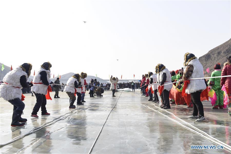 Inheritors of Chagan Lake winter fishing heritage pull the fishing net in Qianyaozi Reservoir in Hohhot, capital of north China\'s Inner Mongolia Autonomous Region, Jan. 26, 2019. A two-day winter fishing tourism festival opened here on Saturday, during which 18 inheritors of Chagan Lake winter fishing showed visitors traditional ways of fishing. Winter fishing on ice-covered Chagan Lake dates back to the Liao and Jin dynasties from 10th century to the 13th century in China and was listed into the national intangible cultural heritage in 2008. (Xinhua/Wang Zheng)