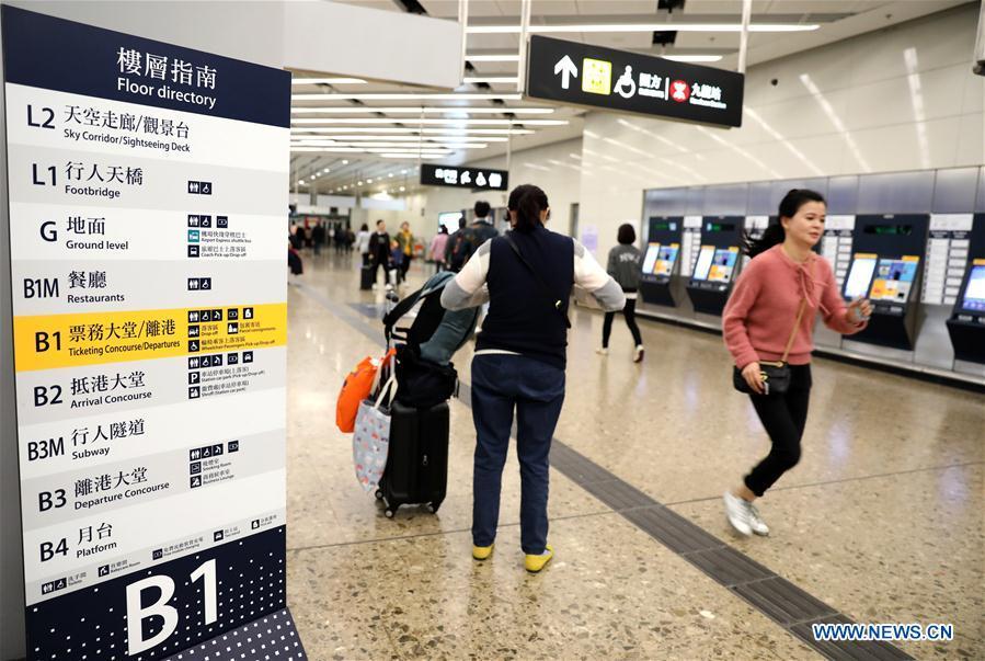 Passengers walk at the West Kowloon railway station in Hong Kong, south China, Jan. 25, 2019. To better serve the passengers using the automotive ticket machines, blue signs are installed and staff members in orange are dispatched to offer help at the West Kowloon railway station in Hong Kong. (Xinhua/Wu Xiaochu)