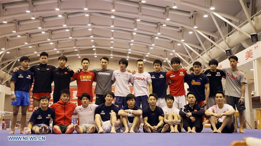 Members of Chinese and Japanese men\'s gymnastics teams pose for a group photo after a training in Beijing, capital of China, Jan. 30, 2019. First-ever China-Japan gymnastics co-training camp started here on Jan. 27. (Xinhua/Luo Yuan)