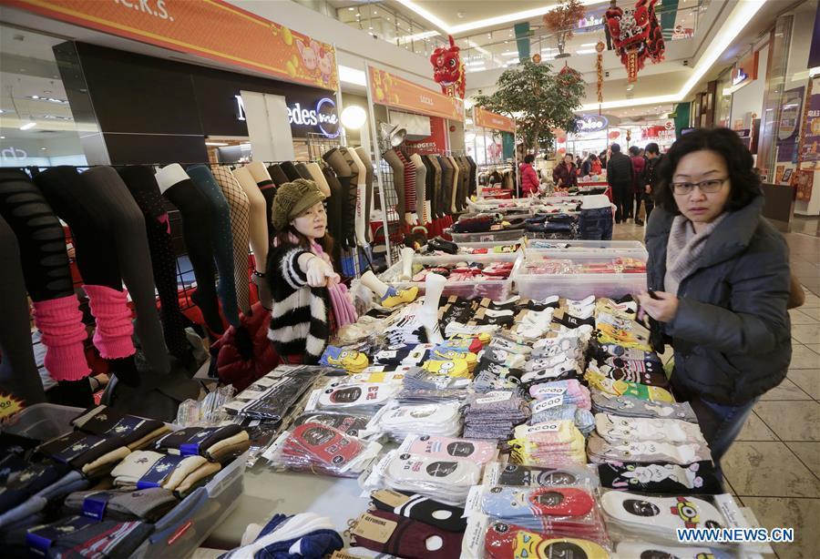 A resident shops for socks while visiting the 30th Chinese Lunar New Year Flower & Gift Fair in Richmond, Canada, Jan. 30, 2019. The seven-day Chinese Lunar New Year Flower & Gift Fair, west Canada\'s largest indoor Lunar New Year festivity, was opened on Tuesday. (Xinhua /Liang Sen)
