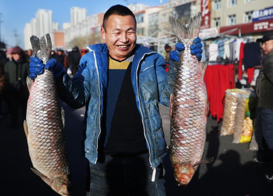 A fisherman catches two fish before selling them at a market in Yanqing district, Beijing. (Photo by Tian Baoxi/Provided to chinadaily.com.cn)

Fishing season has opened on Yeya Lake in Yanqing, Beijing\'s northwestern district, with villagers catching the first haul of fish in celebration of the upcoming Spring Festival.

On the 1,300-hectare lake of Heimuwa village, fishermen are out trying to catch fish. Liu Changhai, who caught almost 300 kilos of fish in significant haul, said he is excited for the harvest. \