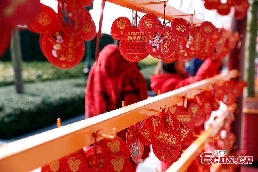 A visitor puts up her wish card in Shanghai Disney Resort to greet \