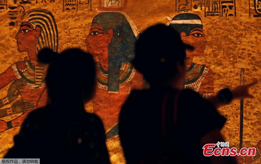 Visitors look at ancient Egyptian drawings on the newly renovated wall of boy pharaoh King Tutankhamun\'s tomb in Valley of the Kings in Luxor, Egypt January 31, 2019. A century after the tomb of Tutankhamun was discovered, revealing the mummified boy-king buried more than 3,000 years ago, it has re-opened, brighter and safer thanks to painstaking work to repair damage caused by dust, damp and visitors. (Photo/Agencies)