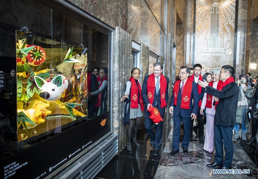 Chinese Consul General in New York Huang Ping (3rd L) visits the window display featuring the Chinese Lunar Year of Pig with John B. Kessler (2nd L), president of the Empire State Realty Trust Inc., after the lighting ceremony for Chinese Spring Festival at the Empire State Building in Manhattan, New York, the United States, on Feb. 1, 2019. The top of the landmark Empire State Building in Manhattan will shine in red, blue and yellow on the nights of next Monday and Tuesday to celebrate the Chinese New Year, which falls on Feb. 5 this year. (Xinhua/Wang Ying)