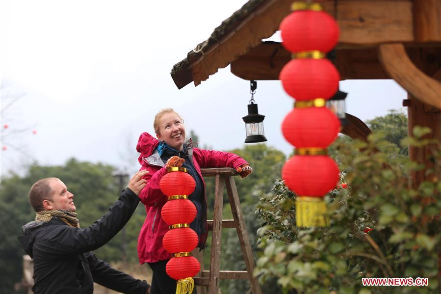 A British couple hang red lanterns for the upcoming Spring Festival at a hostel in Wulingyuan District of Zhangjiajie City, central China\'s Hunan Province, Jan. 31, 2019. The Spring Festival, or the Chinese Lunar New Year, falls on Feb. 5 this year. (Xinhua/Wu Yongbing)