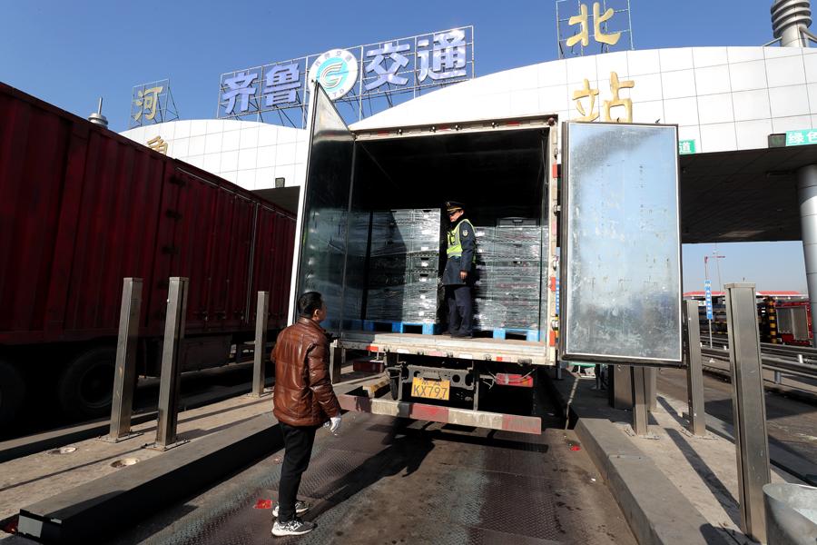 A vegetable transporter\'s vehicle undergoes inspection before entering Beijing. (Photo by WANG JING/CHINA DAILY)