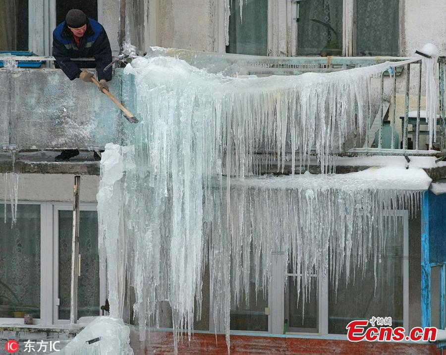 A man moves ice on a residential building in Ivanovo, Russia, Feb. 11, 2019. (Photo/IC)