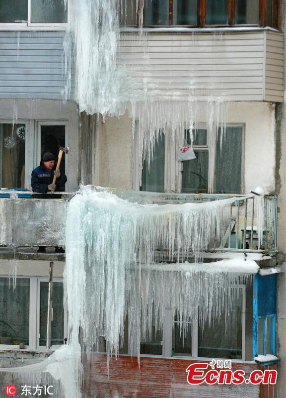 A man moves ice on a residential building in Ivanovo, Russia, Feb. 11, 2019. (Photo/IC)