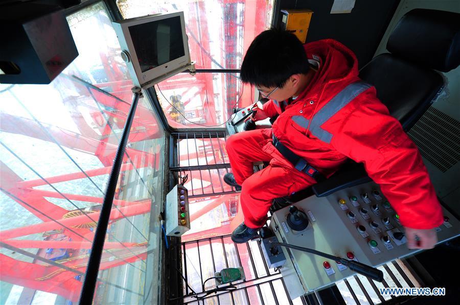 Gong Fuqiang, a crane driver, works at the operator\'s cab at Zhenghe Xinggang Terminals of Taicang Port in Suzhou, east China\'s Jiangsu Province, Feb. 11, 2019, the first workday after Spring Festival holiday. (Xinhua/Ji Haixin)