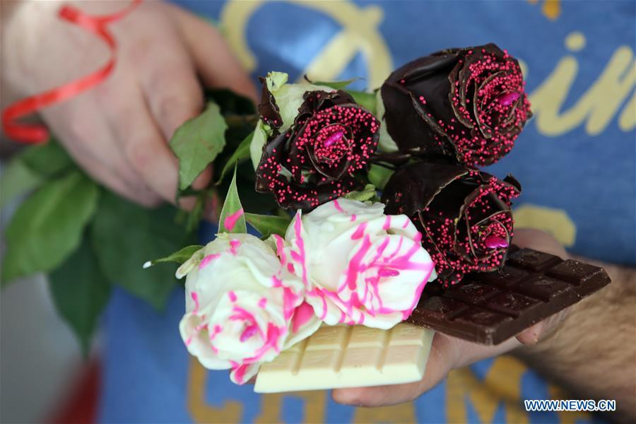 Photo taken on Feb. 13 shows chocolate-coated roses held by Ante Jurkovic, owner of a flower shop in Rijeka, Croatia, Feb. 13, 2019. Jurkovic invented the technic to coat roses with chocolate in preparation for Valentine\'s Day. (Xinhua/Goran Kovacic)