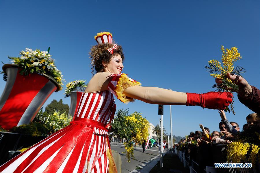 A performer distributes flowers during the parade of Nice Carnival with the theme \