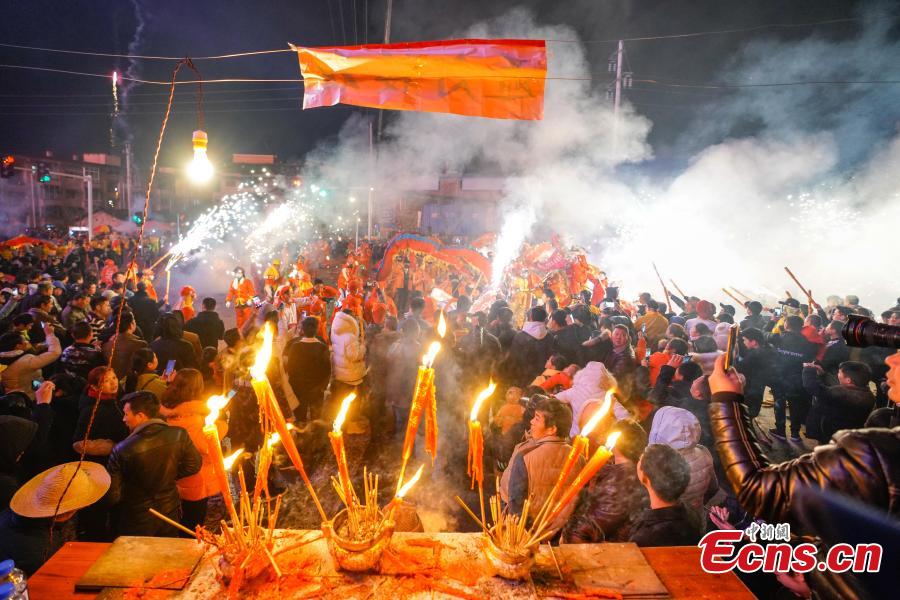 People perform dragon dance with a background of firecrackers in Yuqing County, southwest China\'s Guizhou Province, Feb. 16, 2019. Villagers gathered and performed dragon dances to celebrate the upcoming Lantern Festival,which falls on Feb. 19 this year.