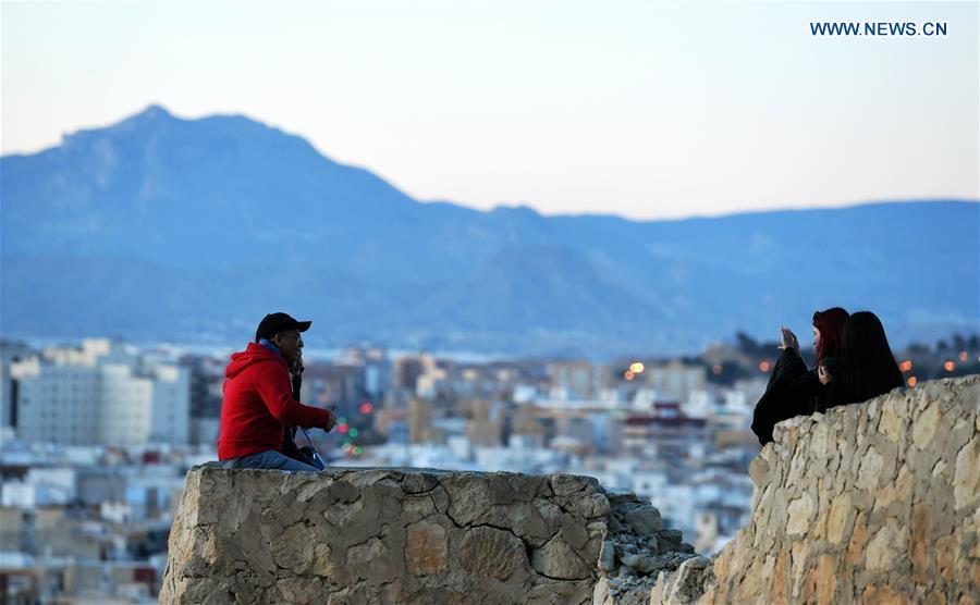 Tourists take pictures by the Santa Barbara Castle in the city of Alicante, Spain, Feb. 16, 2019. (Xinhua/Guo Qiuda)