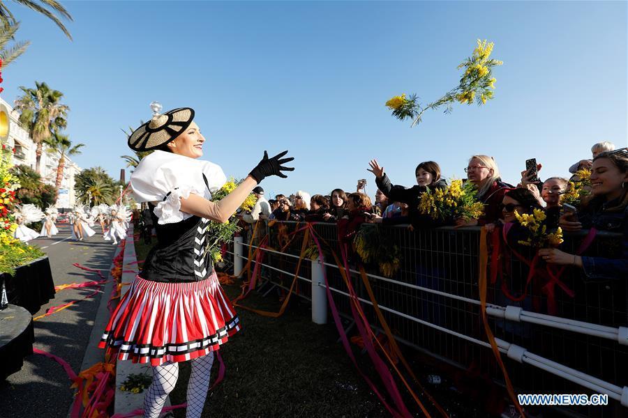 A performer distributes flowers during the parade of Nice Carnival with the theme \