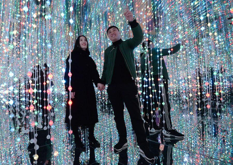 A couple holds hands at the 3D immersive pavilion in Handan city, Hebei province, on Feb 14, 2019. (Photo by Hao Qunying/Asianewsphoto)