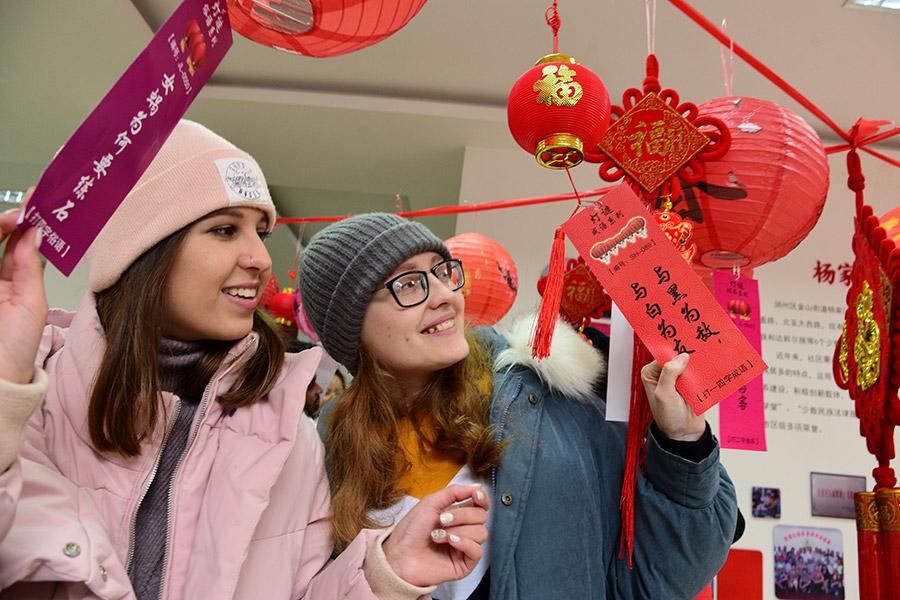 Two students from Russia attend a local riddle-solving activity in Zhenjiang, Jiangsu Province on Thursday. (PHOTO BY SHI YUCHENG/FOR CHINA DAILY)
The making of tangyuan is more like making dumplings-the glutinous rice flour dough is molded into round wrappings and fillings are put inside before they are rolled into balls.

Both yuanxiao and tangyuan have similar sweet-flavored fillings, such as red bean paste, black sesame and crushed peanuts. But tangyuan also has savory fillings, including preserved vegetables with pork and mushroom.

Liu Yang, executive chef of Huaiyang cuisine restaurant, Youyuan Jingmeng, who is also a native of Yangzhou in Jiangsu province, remembers when he was a child, each family made their own savory tangyuan with shepherd\'s purse (a spring seasonal wild vegetable) and pork fillings.

Yuanxiao or tangyuan are both usually boiled and eaten with soup, but the soup is a bit different-the tangyuan soup is usually clear, and the yuanxiao soup is often opaque.

In northern China, there\'s another way of cooking yuanxiao-frying. The trick is to fry it without causing the filling to burst out. To do that, the oil needs to be 70-percent-hot oil and the yuanxiao should be fried for 30 seconds. Stab several small holes in the surface, and fry them again for four to five minutes to ensure a crispy crust.