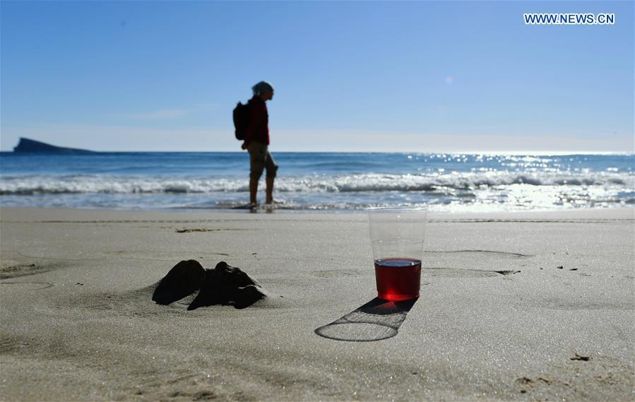 A young man enjoys sunshine by the seaside in the city of Benidorm, the Province of Alicante, Spain, Feb. 16, 2019. (Xinhua/Guo Qiuda)