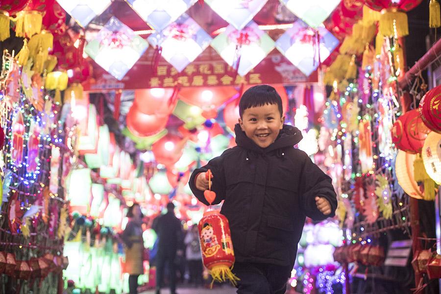 A boy runs happily in a corridor lit up with lanterns to celebrate Lantern Festival in Baibuting community, Wuhan, Hubei Province, in March 2018. (PHOTO/XINHUA)

As the first full moon of the new year approaches, China prepares to celebrate Lantern Festival.

Lantern Festival, or yuanxiaojie in pinyin, which comes on the 15th day of the first lunar month, is the first festival after the celebration of Lunar New Year in China.

The tradition dates back to more than 2000 years ago-during the Han Dynasty (206 BC-AD 220) when Buddhism was flourishing in China. Emperor Ming of the Eastern Han Dynasty (25-220) ordered that lanterns be lit in the imperial palace to worship and show respect for Buddha.

During the reign of Emperor Yang of the Sui Dynasty (581-618), a large-scale gala with thousands of people was held over the course of the night to celebrate Lantern Festival.

The tradition of lighting lanterns gradually became a civilian activity, and the lanterns are now made into different sizes, shapes and colors-but all have good wishes for the new year.