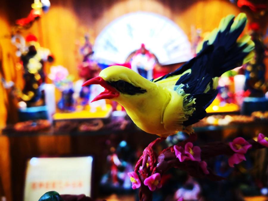 This almost lifelike dough figurine of a bird is created by Gong Yuze. (Photo by Zhang Qingyun for chinadaily.com.cn)