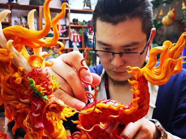 Gong Yuze concentrates intensively as he works on a dough figurine in his studio in Harbin, capital of Northeast China\'s Heilongjiang Province.  (Photo by Zhang Qingyun for chinadaily.com.cn)