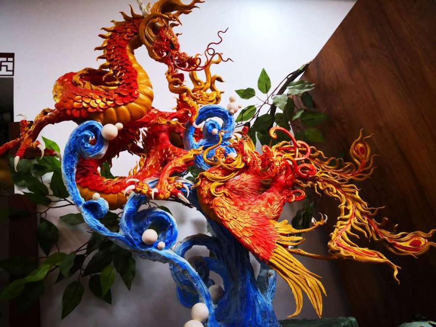 A dough figurine that includes a dragon is created in vivid colors by Gong Yuze. (Photo by Zhang Qingyun for chinadaily.com.cn)