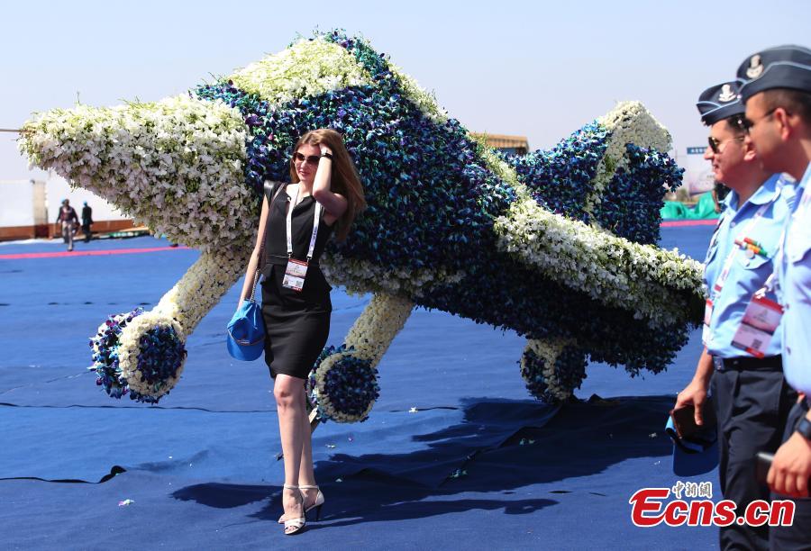 A foreign exhibitor poses next to a floral aircraft model on the inaugural day of Aero India 2019 at Yelahanka air base in Bangalore, India, Feb. 20, 2019.  Over 400 exhibitors from more than 20 countries and regions are participating in Aero India show this year. (Photo/Agencies)