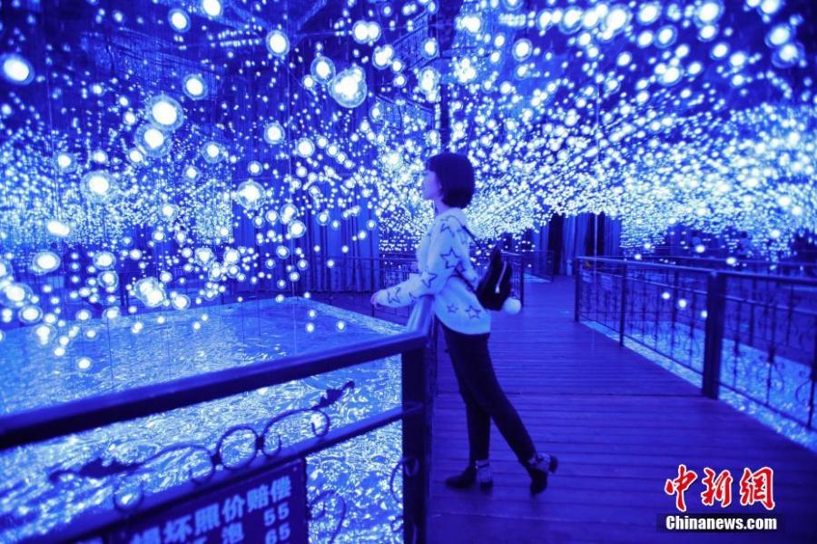 Visitors enjoy a light show on Central Avenue, a major shopping street in Harbin, Northeast China\'s Heilongjiang Province, Feb. 21, 2019. Combining technology with art, it offered interactive games for an immersive experience. (Photo: China News Service/Lyu Pin)