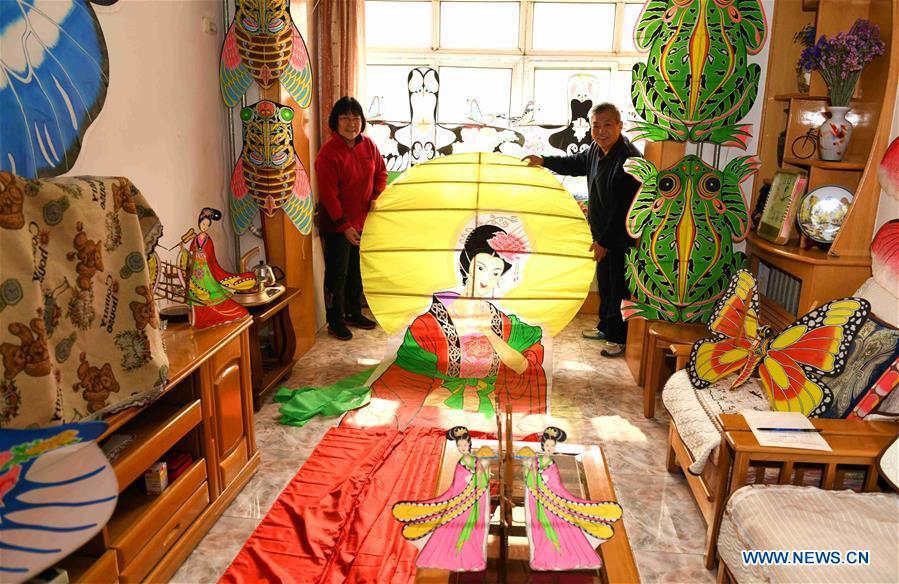 Kite enthusiasts Fu Xianming (R) and Lin Wenqing display one of their kites at home in Shijiazhuang, north China\'s Hebei Province, Feb. 20, 2019. Fu Xianming and his wife Lin Wenqing are known for their passion for kites. The retired school-teacher couple has completed more than 1,500 kites since they began to learn kite-making in 1998. Driven by a wish to master the kite-making crafts, Fu and Lin went on multiple study tours to Weifang, Shandong Province, where traditional Chinese kites originated. Besides enjoying themselves, the couple has also set up a campus workshop for local students who show interest in kite-making. (Xinhua/Chen Qibao)