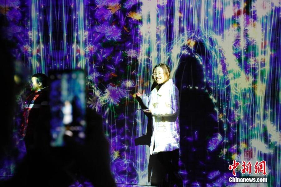 Visitors enjoy a light show on Central Avenue, a major shopping street in Harbin, Northeast China\'s Heilongjiang Province, Feb. 21, 2019. Combining technology with art, it offered interactive games for an immersive experience. (Photo: China News Service/Lyu Pin)