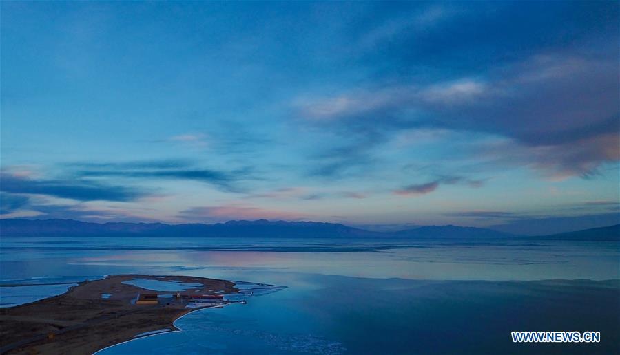 Photo taken on Dec. 21, 2017 shows the sunset glow over the frozen Qinghai Lake in northwest China\'s Qinghai Province. China\'s largest inland saltwater lake saw its water level rise 0.48 meters in 2018 as a result of increased rainfall, the local meteorological center said. Qinghai Lake, situated in northwest China\'s Qinghai Province, has been expanding since 2005. The water level rose to 3,195.41 meters at the end of last year, according to the Qinghai hydrology and water resources investigation bureau. Experts said the rising level of the lake could help increase the area\'s humidity and temperature, which contributes to the improvement of the region\'s wildlife habitat and ecosystem. (Xinhua/Jia Haiyuan)