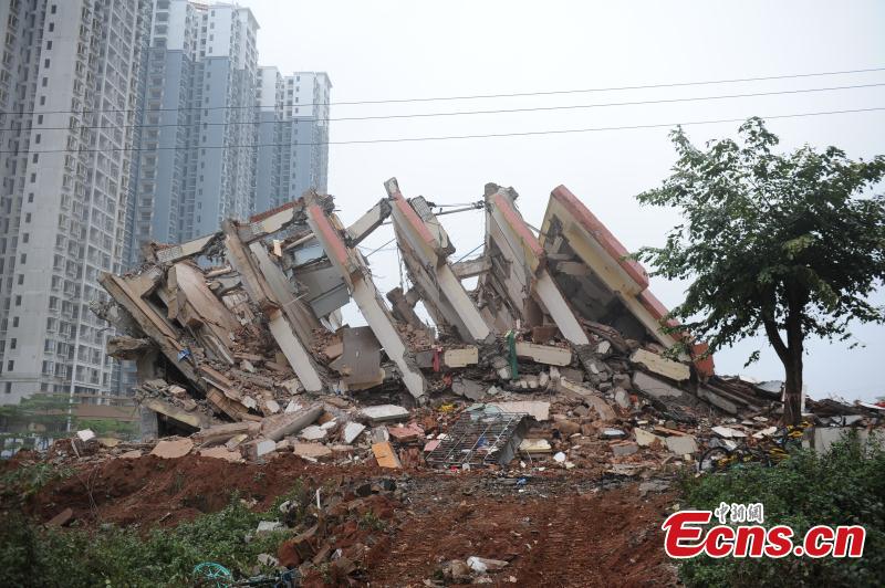 A holdout building is demolished in Haikou City, Hainan Province, Feb. 24, 2019. The eight-story building was left standing for three years due to disagreements over compensation, affecting traffic and the urban landscape. The local government finally reached agreement with homeowners who agreed to relocate.  (Photo: China News Service/Huang Yixiao)