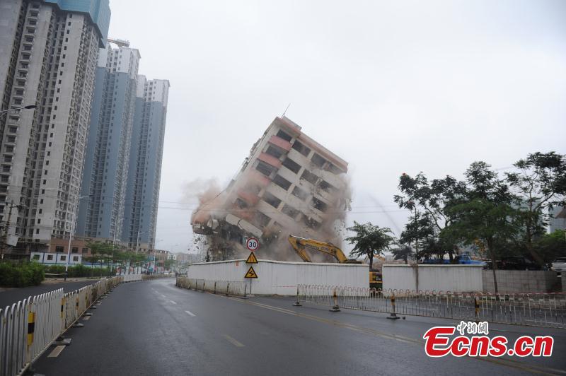 A holdout building is demolished in Haikou City, Hainan Province, Feb. 24, 2019. The eight-story building was left standing for three years due to disagreements over compensation, affecting traffic and the urban landscape. The local government finally reached agreement with homeowners who agreed to relocate.  (Photo: China News Service/Huang Yixiao)