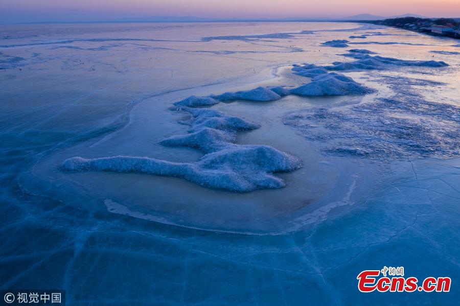 A view of the frozen Xingkai Lake, a border lake between China and Russia, in Northeast China\'s Heilongjiang Province, Feb. 23, 2019. The largest freshwater lake in northeast China, Xingkai is well-known for its abundant biodiversity and complex ecosystems. Local authorities are warning tourists the ice in the lake has begun melting earlier than in the past. (Photo/VCG)
